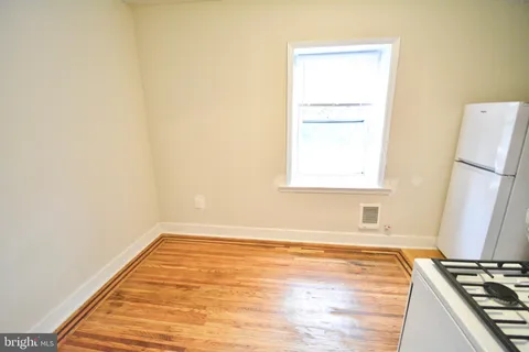a view of a room with wooden floor and a window