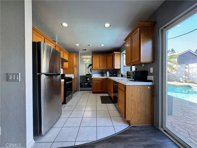 a kitchen with stainless steel appliances granite countertop a refrigerator a sink a stove top oven and a refrigerator
