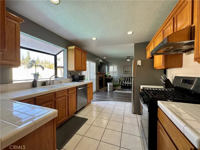 a kitchen with stainless steel appliances granite countertop a stove a sink and a microwave