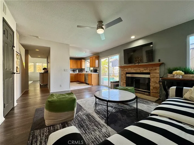 a living room with furniture a flat screen tv and kitchen view