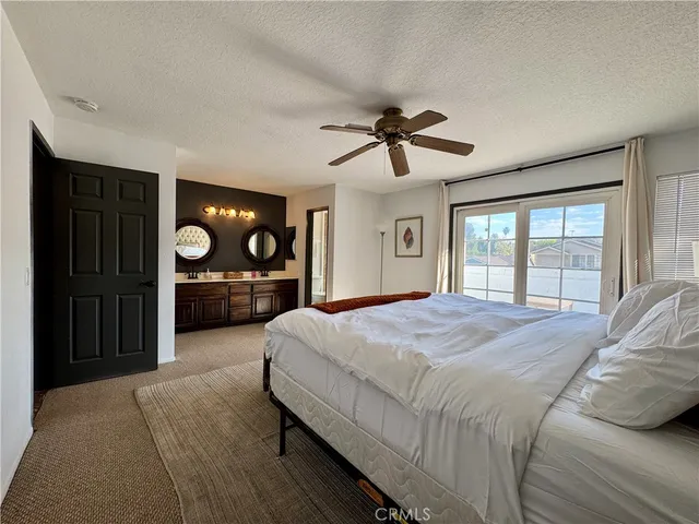 a bedroom with a large bed a chandelier and dresser