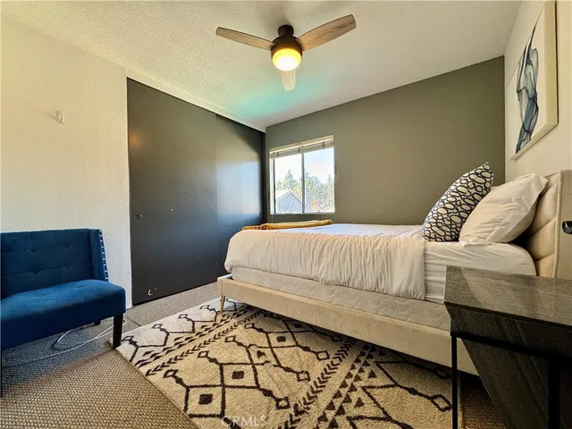 a bedroom with a bed couch and a window