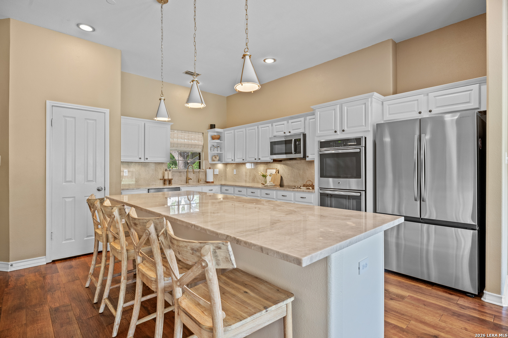 29314 Sumpter Drive Fair Oaks Ranch, TX 78015 - Photo 16 of 44 a kitchen with granite countertop a table chairs stainless steel appliances and wooden floor