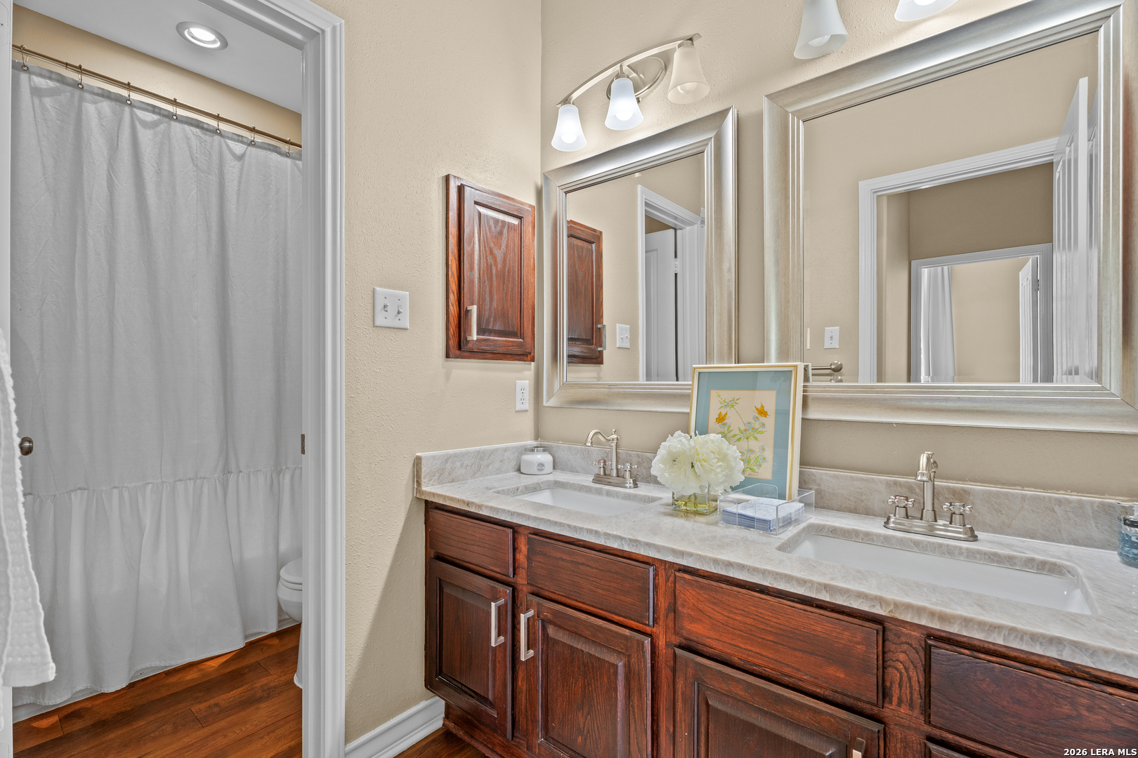 29314 Sumpter Drive Fair Oaks Ranch, TX 78015 - Photo 28 of 44 a bathroom with a double vanity sink and a mirror