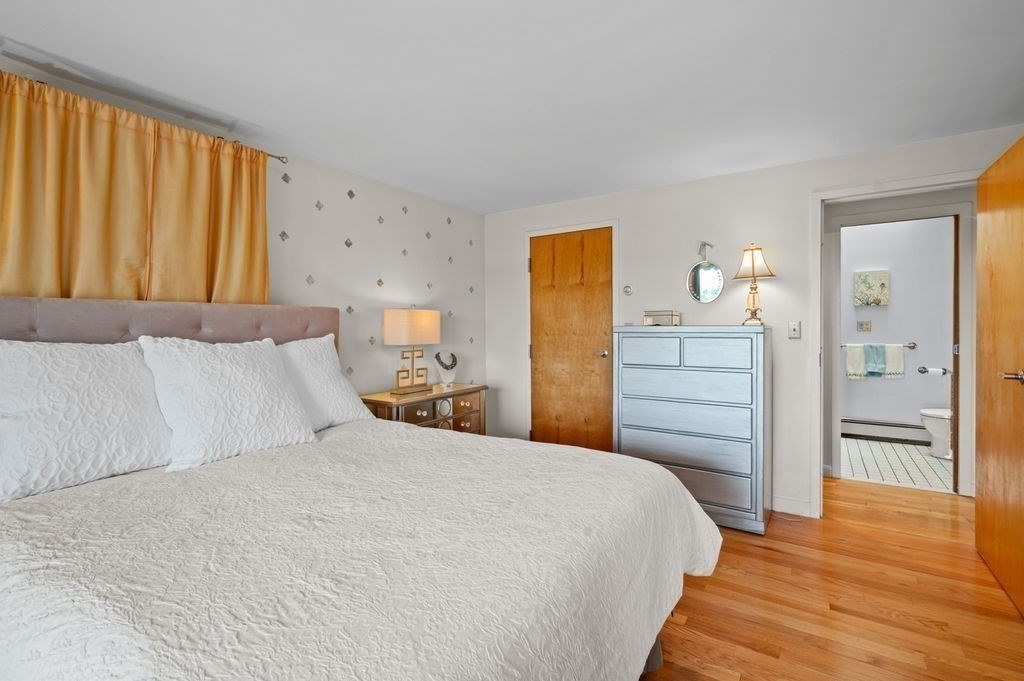 22 Little Neck Road Ipswich, MA 01938 - Photo 27 of 37 a bedroom with a bed and wooden floor
