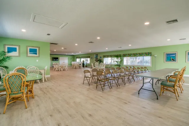 a room with lots of chairs and large windows