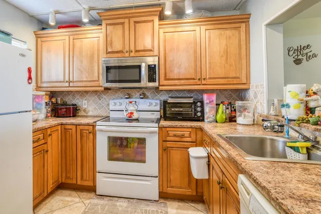 a kitchen with stainless steel appliances granite countertop a sink a stove and cabinets