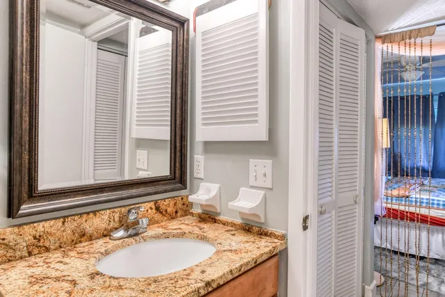 a bathroom with a granite countertop sink and a mirror