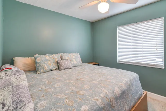 a large bed sitting in a bedroom next to a window