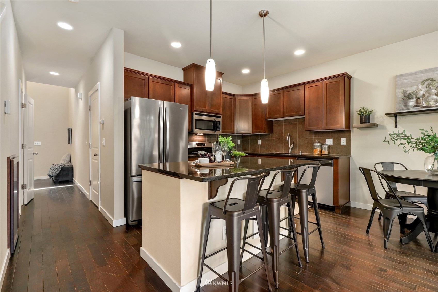 221 164th Place Southeast Bothell, WA 98012 - Photo 7 of 30 a kitchen with stainless steel appliances kitchen island granite countertop a refrigerator a stove a kitchen island a dining table and chairs