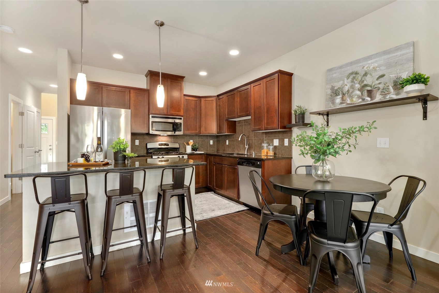 221 164th Place Southeast Bothell, WA 98012 - Photo 8 of 30 a kitchen with stainless steel appliances granite countertop a dining table chairs refrigerator and sink