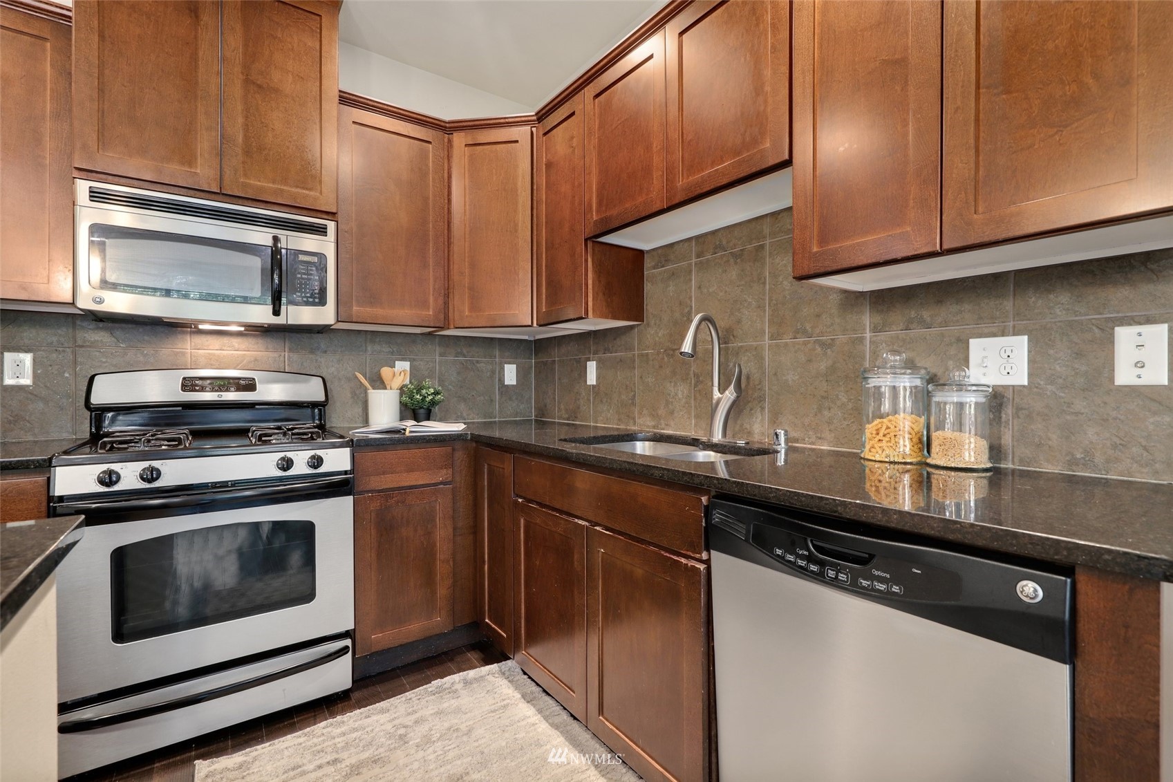 221 164th Place Southeast Bothell, WA 98012 - Photo 9 of 30 a kitchen with stainless steel appliances granite countertop a sink a stove and cabinets