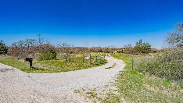 a view of a yard with an ocean and trees