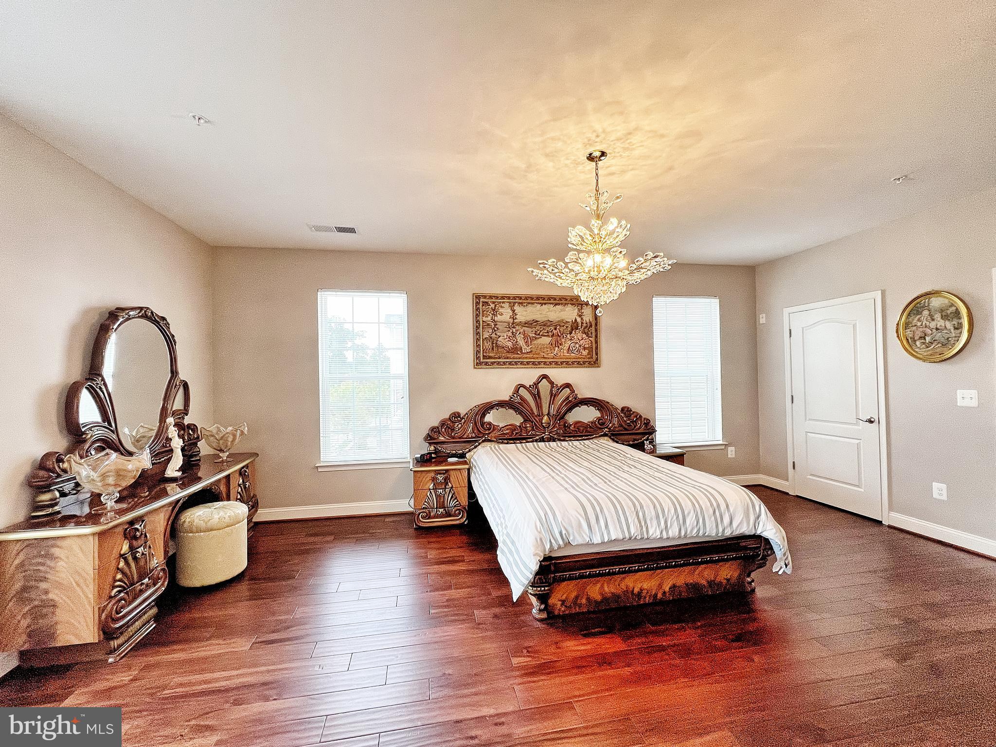605 Quarry View Court, Unit 307 Reisterstown, MD 21136 - Photo 18 of 30 a spacious bedroom with a bed a dresser and wooden floor