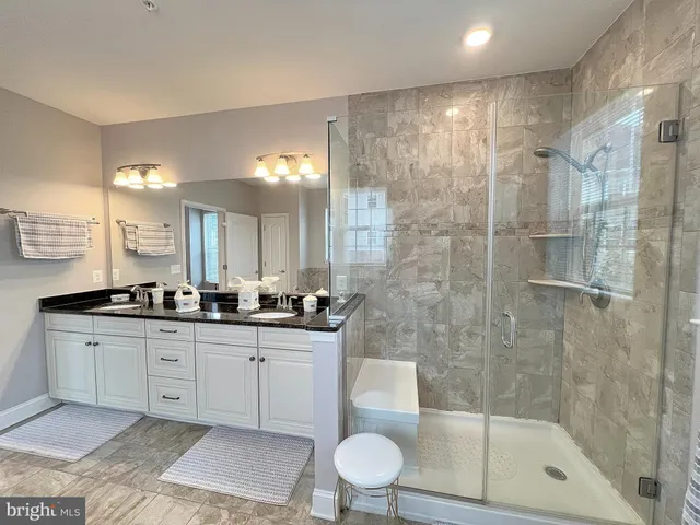 a large spacious bathroom with a granite countertop tub and a large window