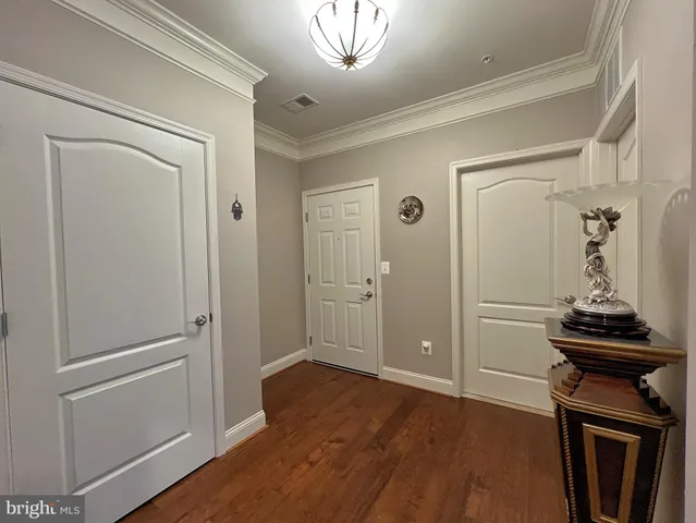 a view of a hallway with wooden floor and cabinets