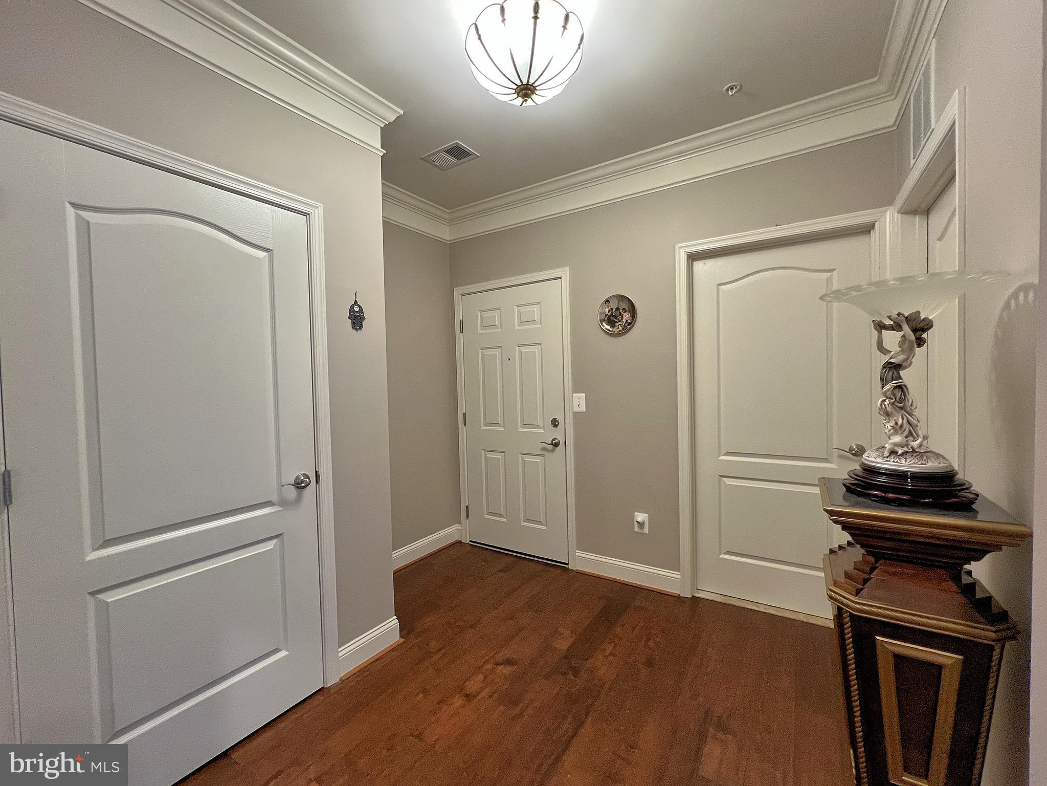 605 Quarry View Court, Unit 307 Reisterstown, MD 21136 - Photo 4 of 30 a view of a hallway with wooden floor and cabinets