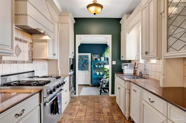 a kitchen with granite countertop a sink stove and cabinets