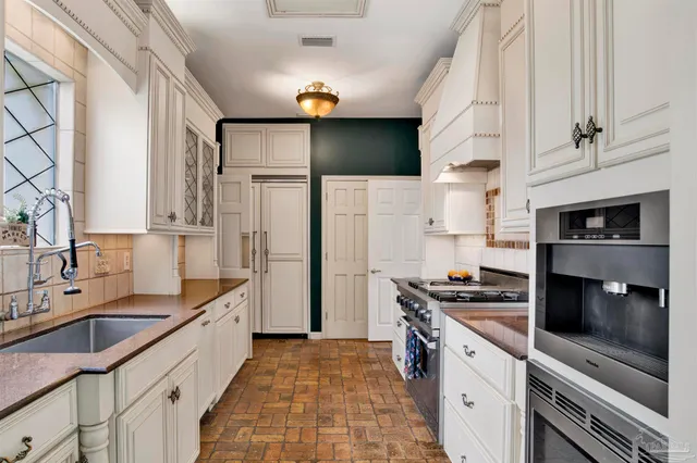 a kitchen with stainless steel appliances a sink stove and refrigerator