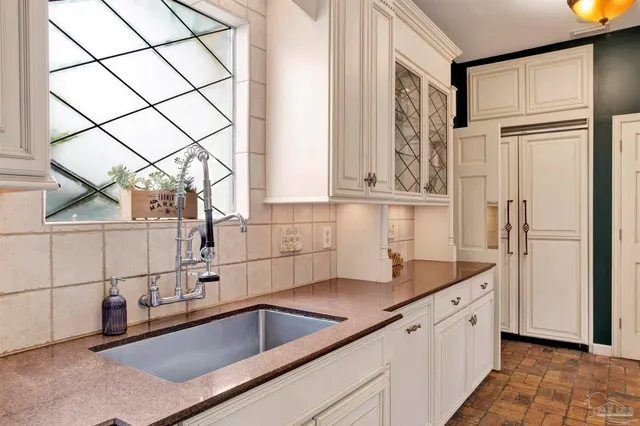 a kitchen with stainless steel appliances granite countertop a sink and a white cabinets