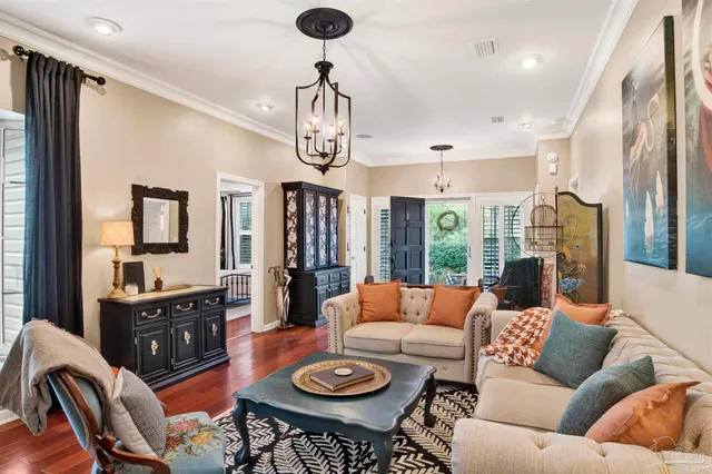 a living room with furniture a fireplace and a chandelier
