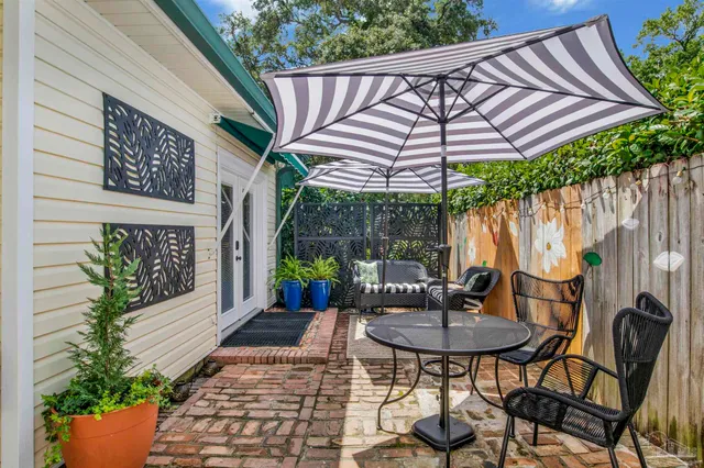a view of a patio with a table and chairs under an umbrella