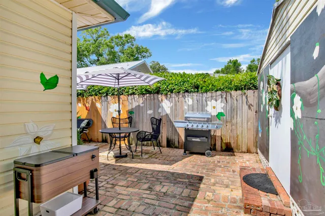 a view of a patio with table and chairs potted plants with wooden fence