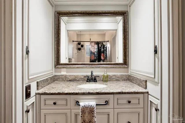 a bathroom with a granite countertop sink and a mirror