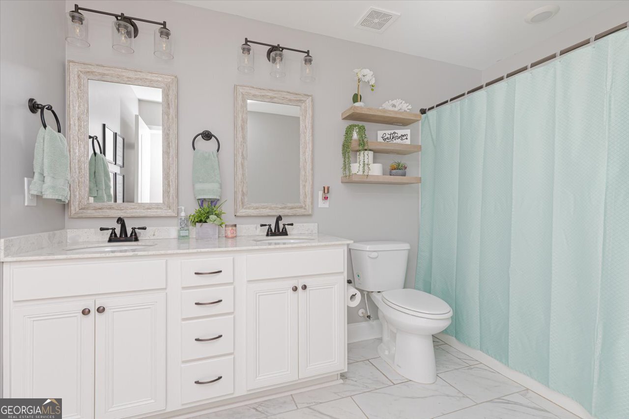 104 Meredith Layne Court Perry, GA 31069 - Photo 33 of 46 a bathroom with a toilet a sink a vanity and mirror