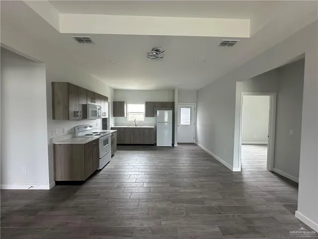 a large kitchen with a wooden floor and a large window