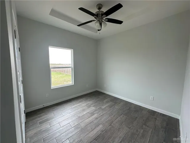 an empty room with a window and a ceiling fan