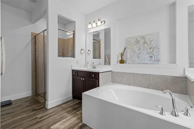a bathroom with a tub a sink and mirror