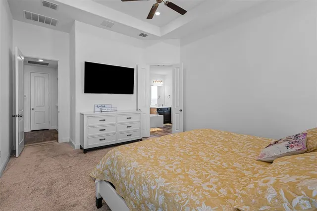 a bedroom with a bed and a flat tv screen on dresser