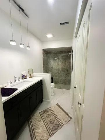 a spacious bathroom with a shower a sink and mirror