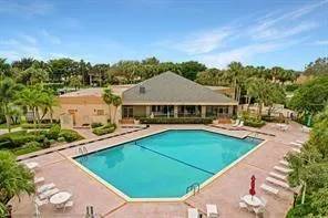 a view of a house with pool and chairs