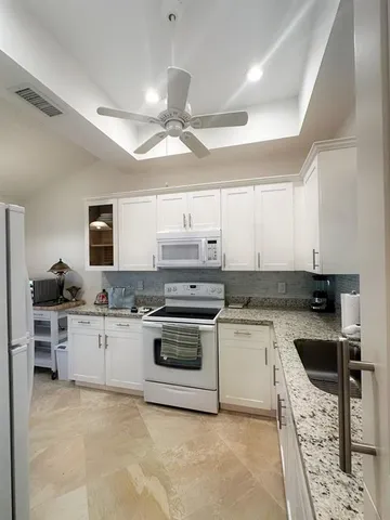 a kitchen with stainless steel appliances granite countertop a stove top oven a sink dishwasher and a refrigerator