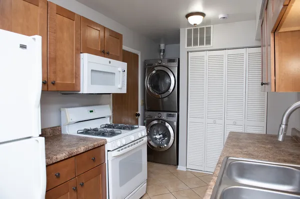 a kitchen with granite countertop a sink a stove and cabinets