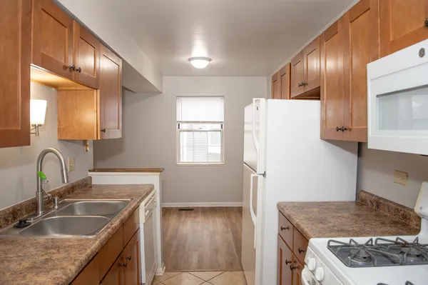 a kitchen with granite countertop a sink stove and refrigerator