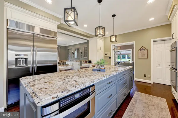 a dining room with wooden floor a chandelier a wooden table and chairs