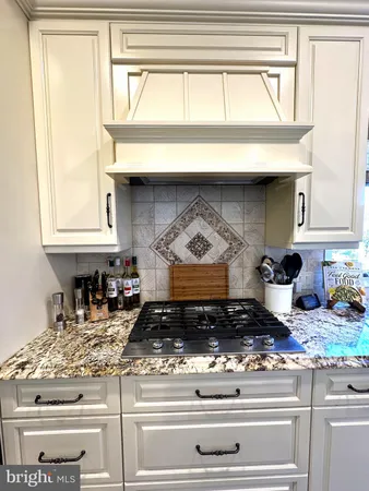 a large white kitchen with sink and black stainless steel appliances