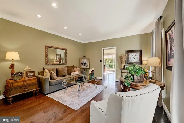 a large living room with stainless steel appliances furniture a rug and a view of kitchen