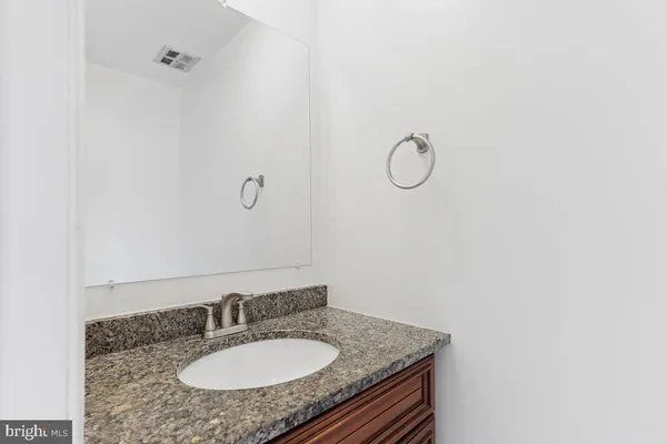 a bathroom with a granite countertop sink and mirror