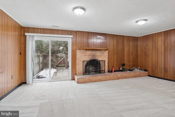a view of an empty room with a fireplace and entryway