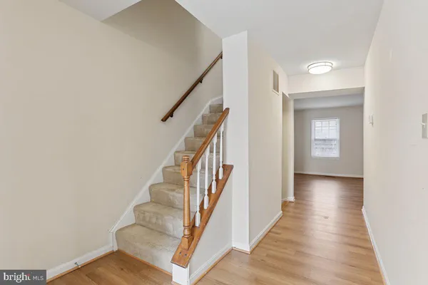 a view of a hallway with wooden floor and entryway