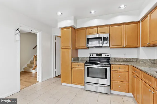 a kitchen with stainless steel appliances granite countertop a stove a refrigerator and a microwave