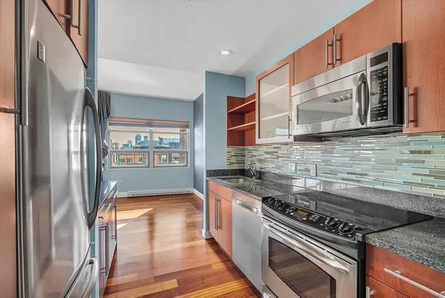 a kitchen with stainless steel appliances granite countertop a sink and a stove