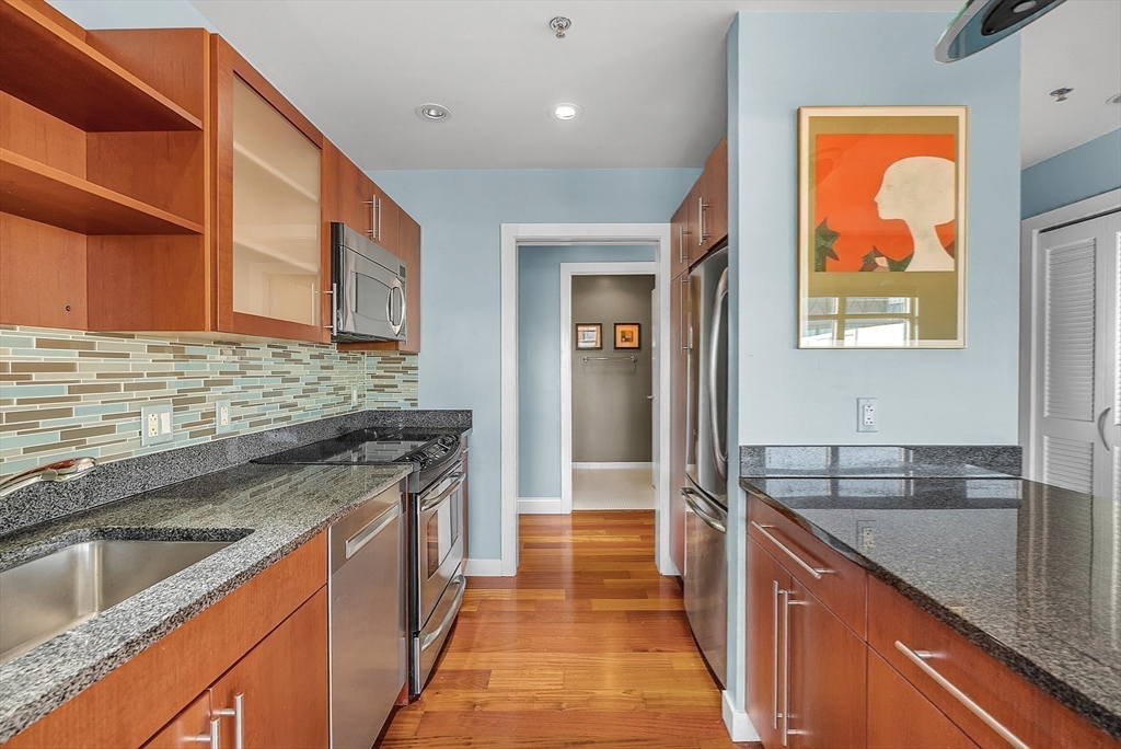 17 Otis Street, Unit 602 Cambridge, MA 02141 - Photo 22 of 40 a kitchen with stainless steel appliances granite countertop a sink and a stove