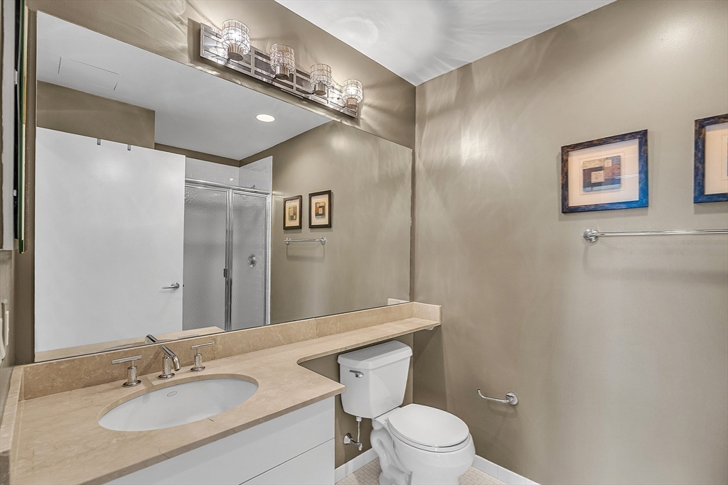 17 Otis Street, Unit 602 Cambridge, MA 02141 - Photo 30 of 40 a bathroom with a toilet a sink and mirror