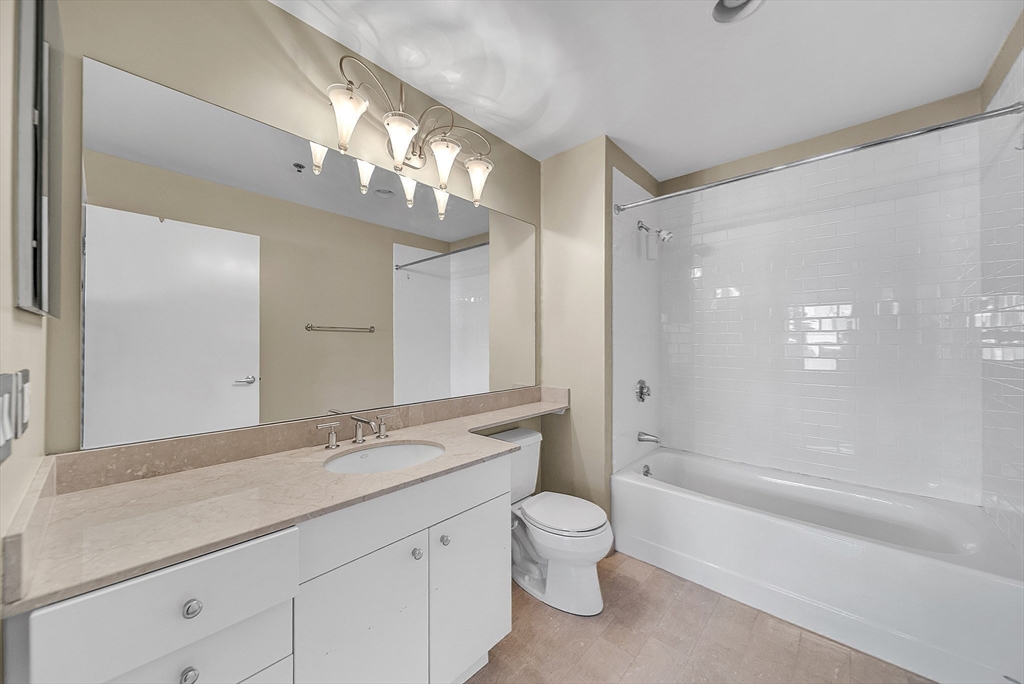 17 Otis Street, Unit 602 Cambridge, MA 02141 - Photo 34 of 40 a spacious bathroom with a granite countertop sink a toilet a mirror and shower