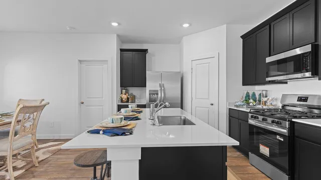 a kitchen with a sink a stove and chairs